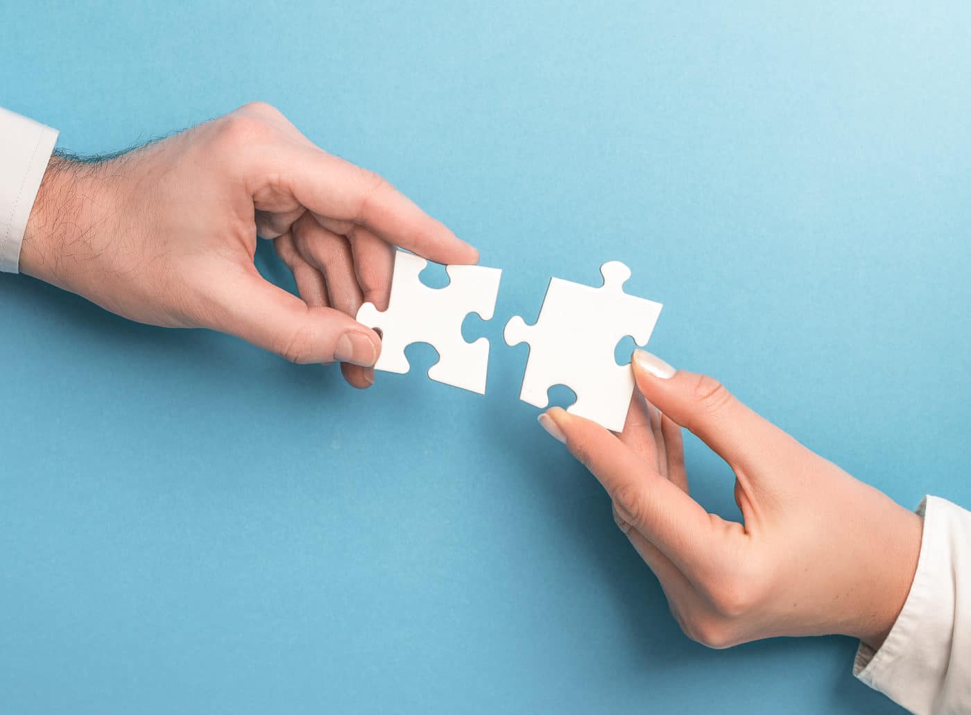 The man and woman holds in hand a jigsaw puzzle. Business solutions, success and strategy concept.
